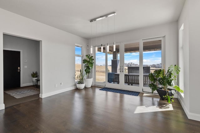 spare room featuring french doors, baseboards, and wood finished floors