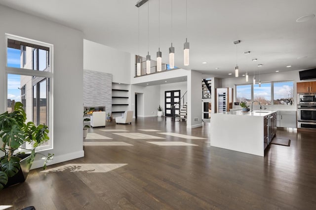 living room featuring stairs, recessed lighting, baseboards, and dark wood-style flooring