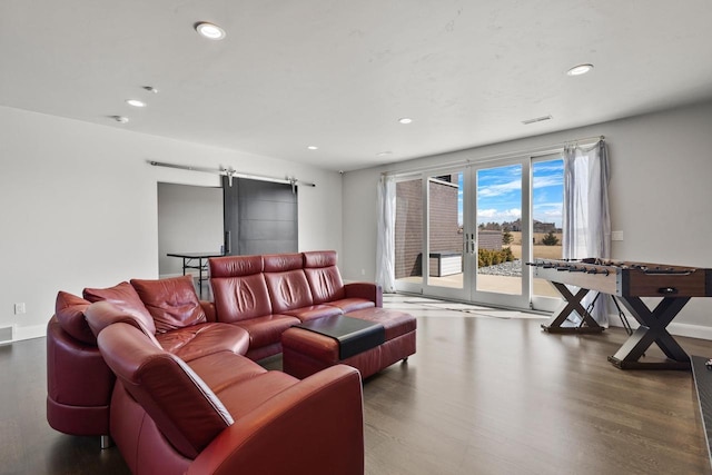 living room with visible vents, wood finished floors, recessed lighting, a barn door, and baseboards