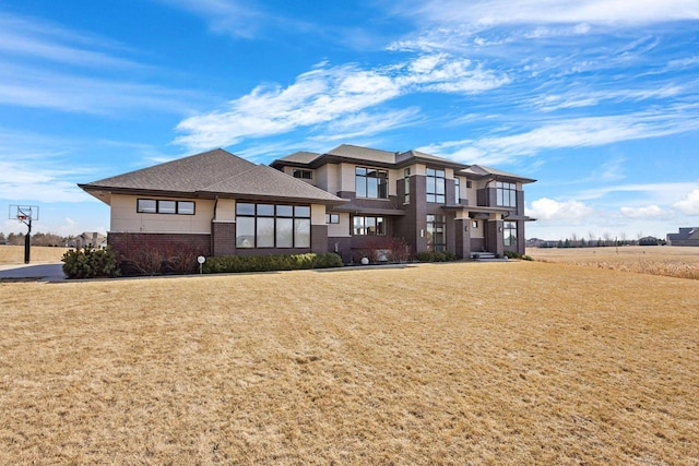 back of property featuring a yard and brick siding