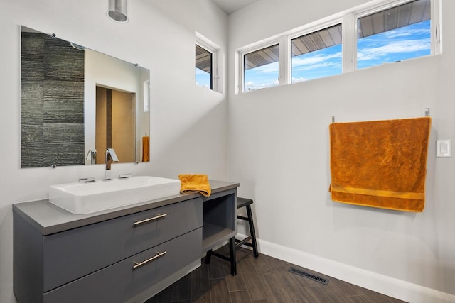 bathroom with visible vents, baseboards, wood finished floors, and vanity