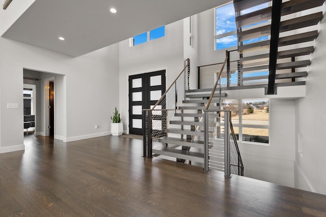 foyer featuring baseboards, recessed lighting, french doors, a high ceiling, and wood finished floors