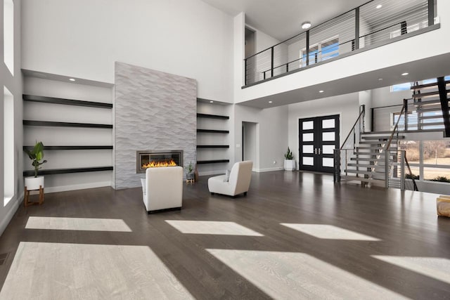 living area with plenty of natural light, french doors, baseboards, and wood finished floors