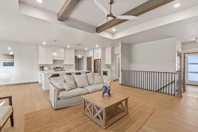 living room featuring beamed ceiling, recessed lighting, light wood-type flooring, and ceiling fan