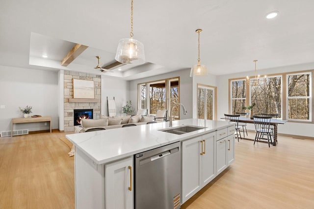 kitchen with a sink, visible vents, light wood-type flooring, and dishwasher