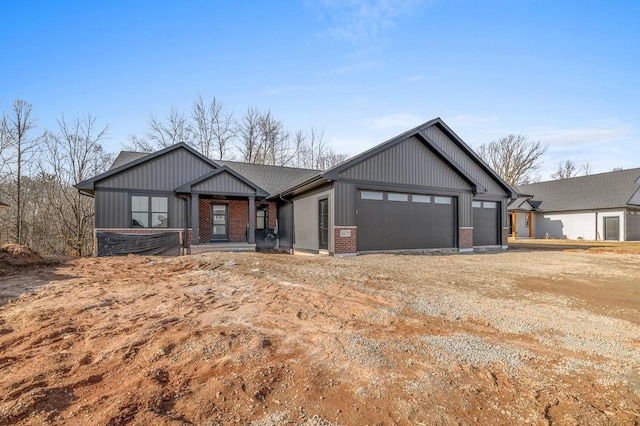 view of front of property with an attached garage, brick siding, board and batten siding, and driveway