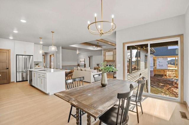 dining space featuring recessed lighting, ceiling fan with notable chandelier, visible vents, and light wood finished floors