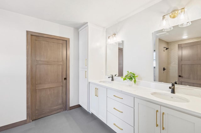 full bathroom featuring double vanity, baseboards, a tile shower, and a sink