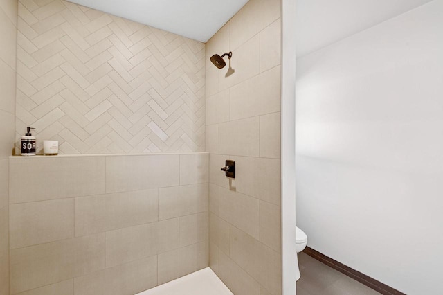 bathroom featuring toilet and a tile shower