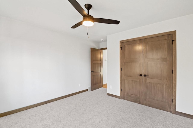 unfurnished bedroom with baseboards, carpet floors, a closet, and ceiling fan