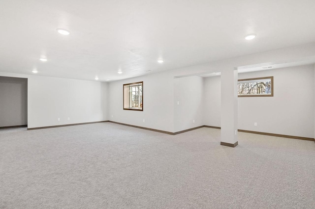 basement with light carpet, plenty of natural light, and baseboards