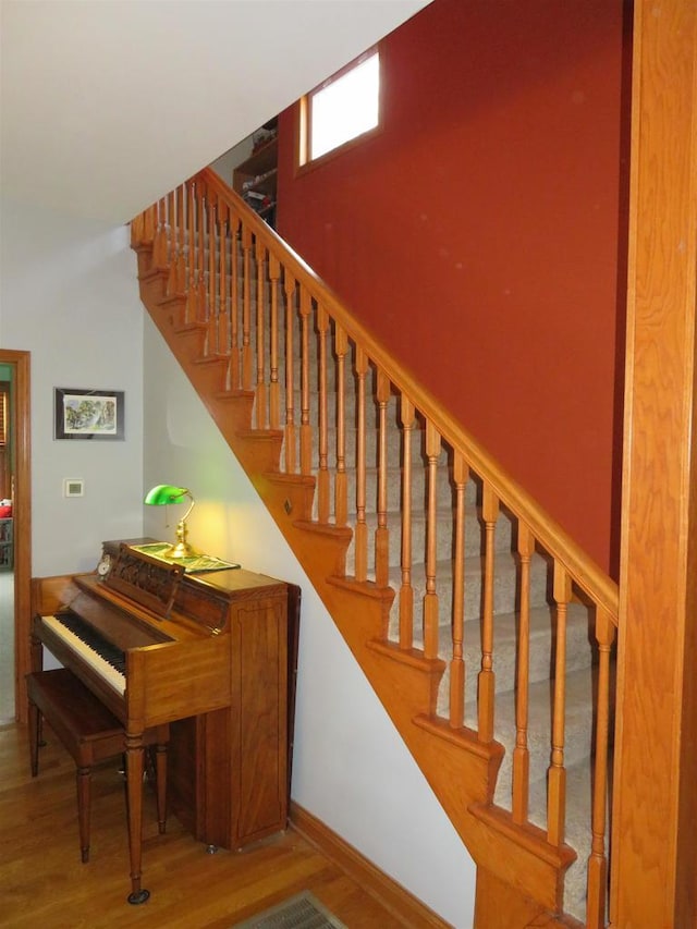 stairway featuring baseboards and wood finished floors