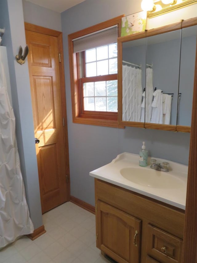 full bath featuring curtained shower, baseboards, and vanity