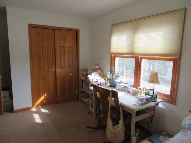 carpeted dining space featuring baseboards