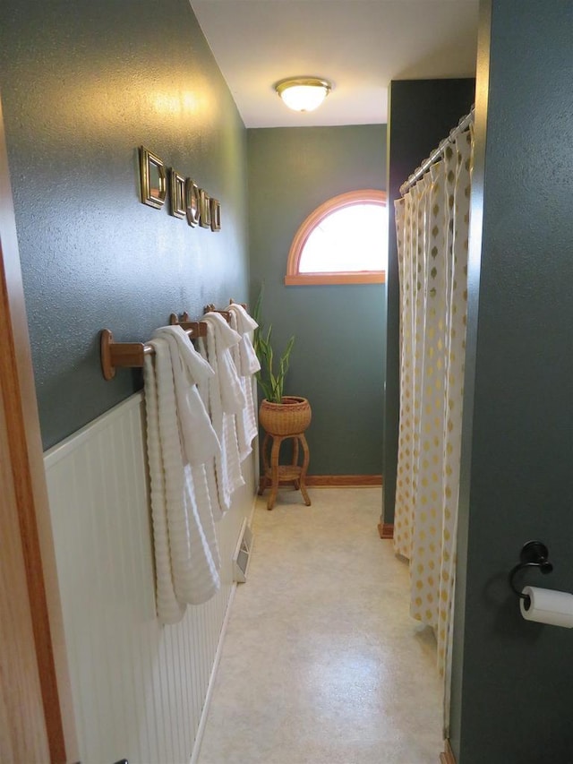 full bathroom featuring visible vents, curtained shower, baseboards, and wainscoting