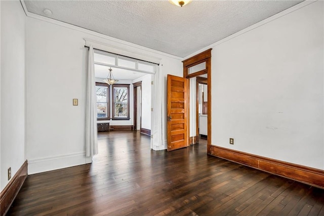 unfurnished room featuring hardwood / wood-style flooring, a textured ceiling, radiator, crown molding, and baseboards