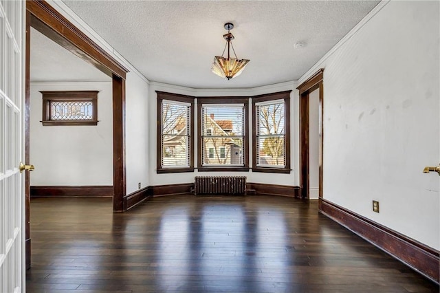 spare room with hardwood / wood-style floors, radiator, and plenty of natural light