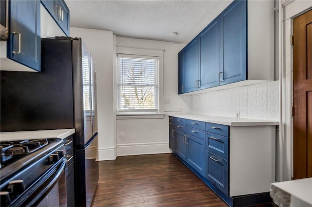 kitchen with a textured ceiling, light countertops, blue cabinets, and dark wood-type flooring