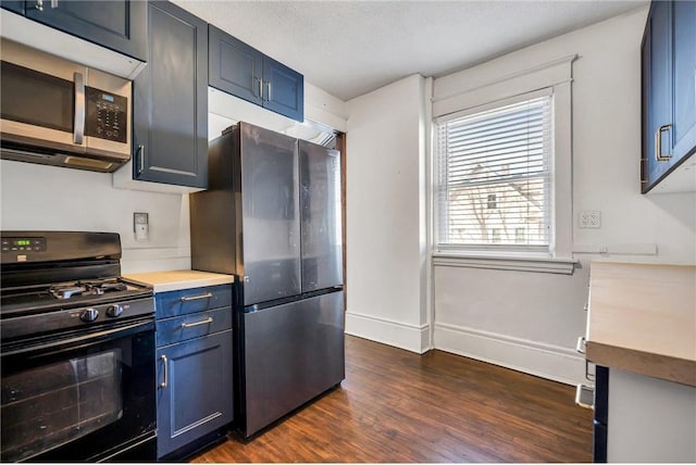 kitchen featuring blue cabinetry, stainless steel appliances, light countertops, baseboards, and dark wood-style flooring