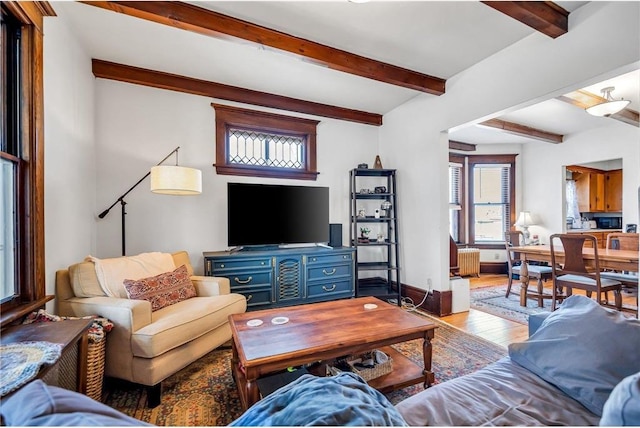 living room featuring beam ceiling, radiator heating unit, baseboards, and wood finished floors