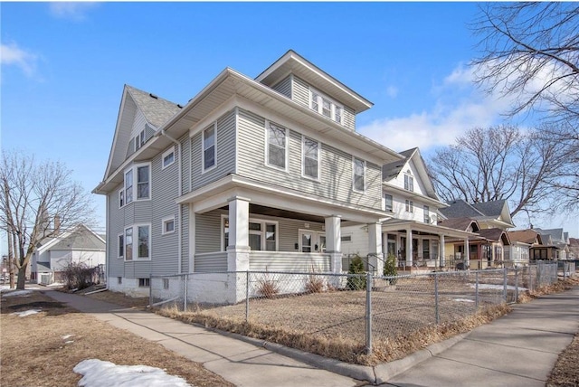 traditional style home featuring a fenced front yard and a porch