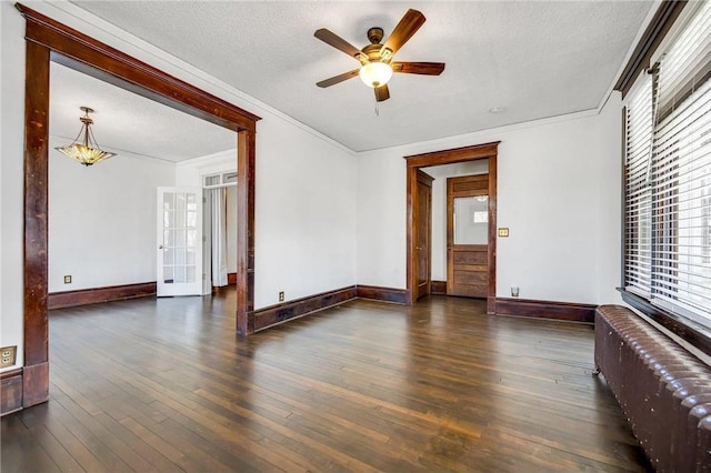 empty room with a ceiling fan, a textured ceiling, hardwood / wood-style floors, radiator, and crown molding