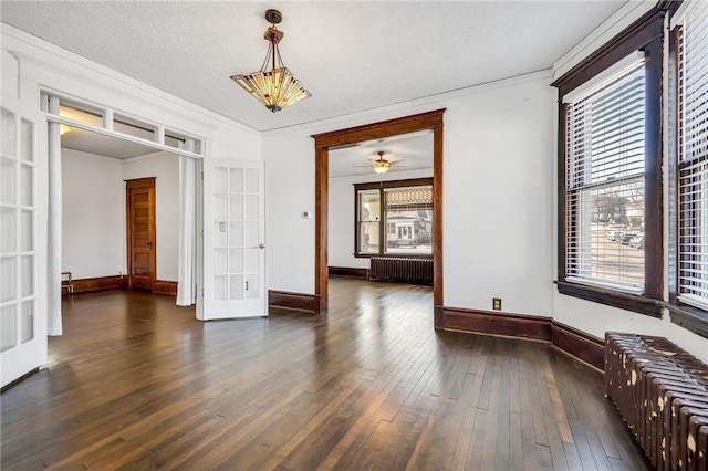 spare room featuring french doors, dark wood-type flooring, radiator, and plenty of natural light