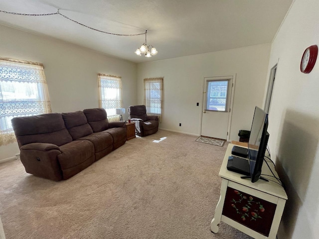 living room with carpet flooring, baseboards, and a chandelier