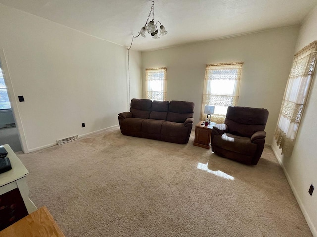 carpeted living area featuring visible vents, baseboards, and a chandelier