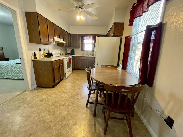 kitchen with white appliances, a ceiling fan, a sink, light countertops, and under cabinet range hood