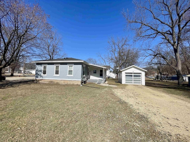 view of front facade with a detached garage, an outdoor structure, and driveway