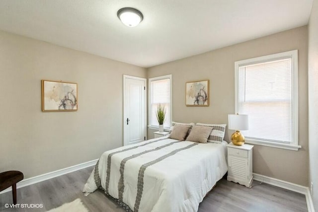 bedroom featuring baseboards and wood finished floors