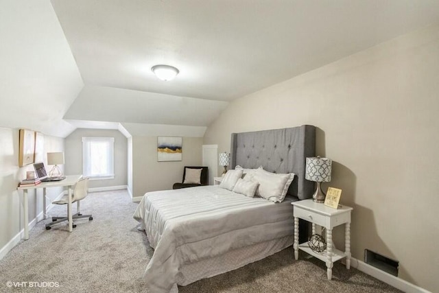 carpeted bedroom featuring baseboards and lofted ceiling