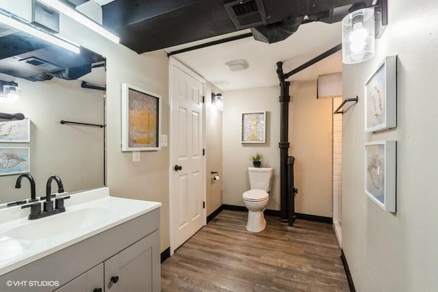 bathroom featuring visible vents, toilet, wood finished floors, baseboards, and vanity