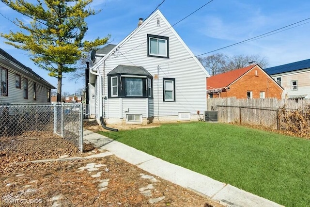 back of property with central air condition unit, a yard, and fence