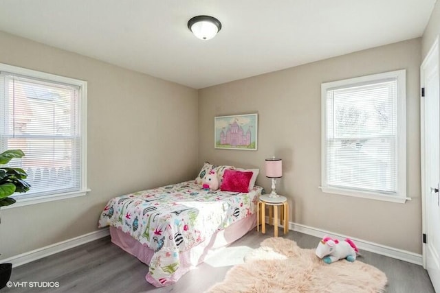 bedroom with wood finished floors and baseboards