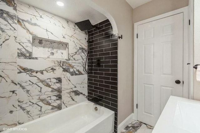 full bathroom featuring marble finish floor, bathtub / shower combination, and a sink