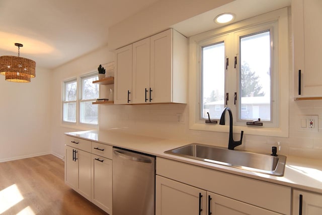 kitchen featuring a sink, tasteful backsplash, dishwasher, and light countertops