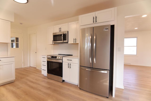 kitchen featuring white cabinetry, light countertops, light wood-style floors, and stainless steel appliances