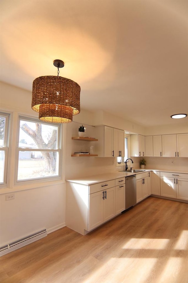 kitchen with light wood finished floors, dishwasher, a baseboard radiator, white cabinetry, and a sink