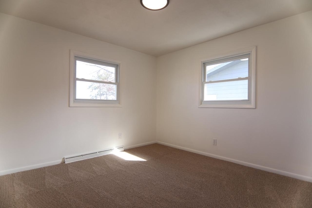 empty room with baseboard heating, carpet flooring, and baseboards