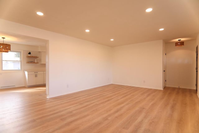 unfurnished room featuring recessed lighting, a baseboard heating unit, light wood-type flooring, and baseboards