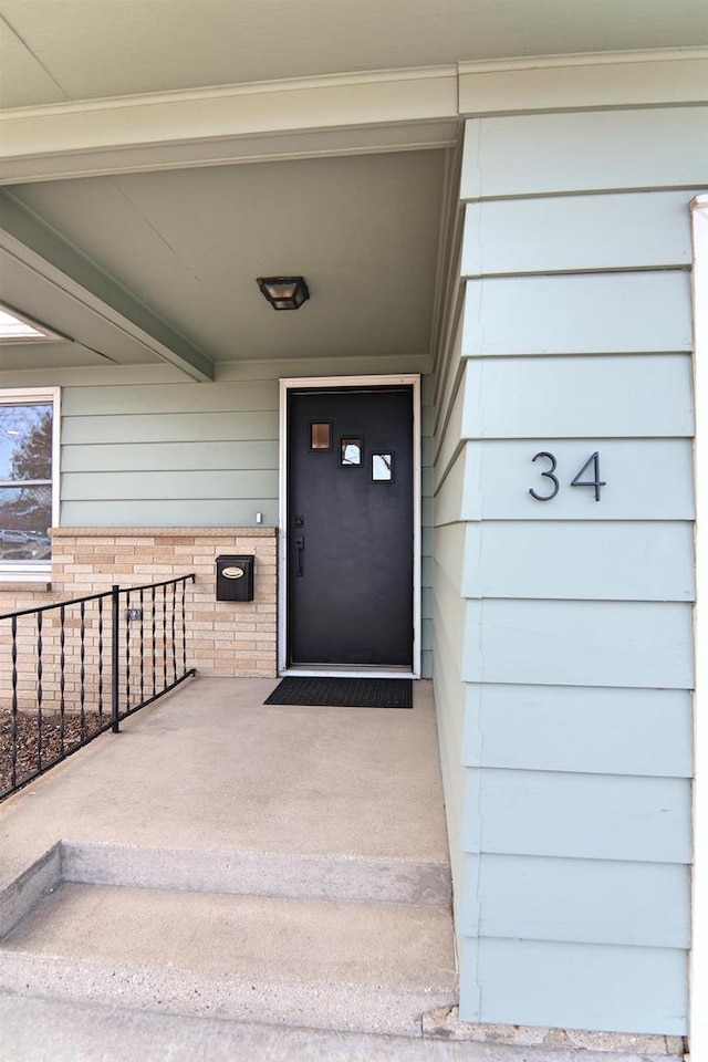 doorway to property featuring brick siding