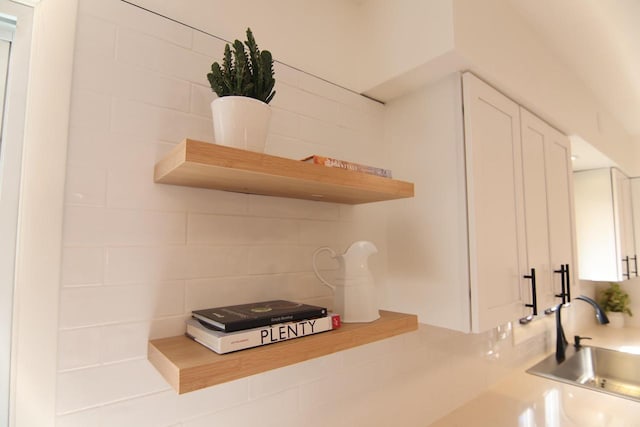 kitchen featuring white cabinets, open shelves, and a sink