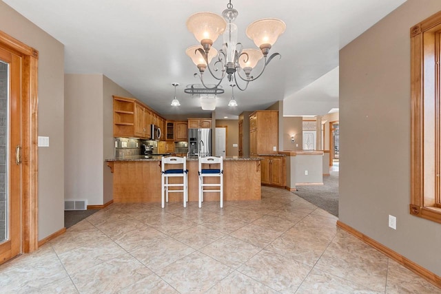 kitchen with visible vents, a peninsula, stainless steel appliances, and open shelves