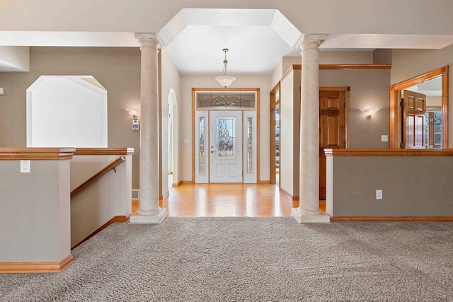 foyer with plenty of natural light, carpet, and ornate columns