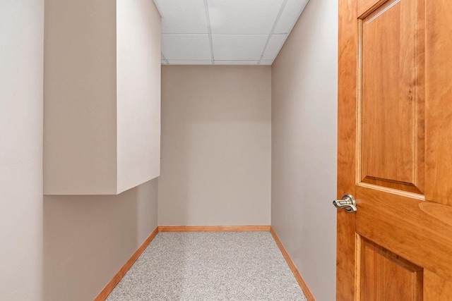 interior space featuring a drop ceiling, baseboards, and carpet flooring