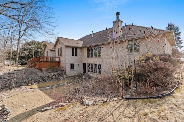 back of house with a wooden deck and a chimney