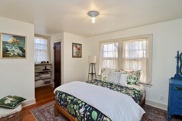 bedroom with wood finished floors and baseboards