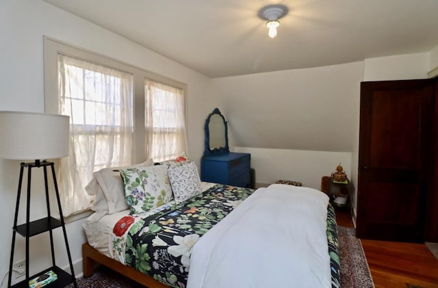 bedroom featuring lofted ceiling and wood finished floors